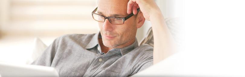Man with glasses looking at a laptop